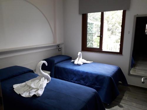two swans sitting on beds in a room at Inteserras in Triei
