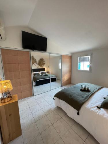 ein Schlafzimmer mit einem Bett und einem TV an der Wand in der Unterkunft Appartement avec piscine in Grimaud