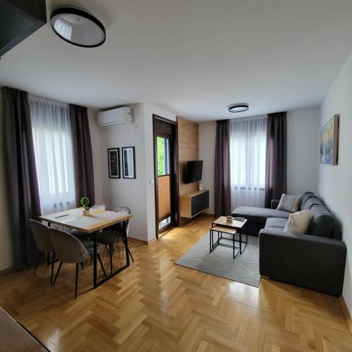 ein Wohnzimmer mit Sofa und Tisch in der Unterkunft PIK Apartmani in Vrnjačka Banja