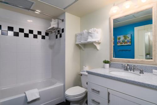 a bathroom with a sink and a toilet and a mirror at Harbour House at the Inn 316 in Fort Myers Beach