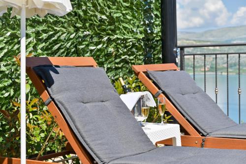 two lounge chairs on a balcony with a view of the water at Luxury Villa Sun Stone heated pool & whirlpool in Trogir