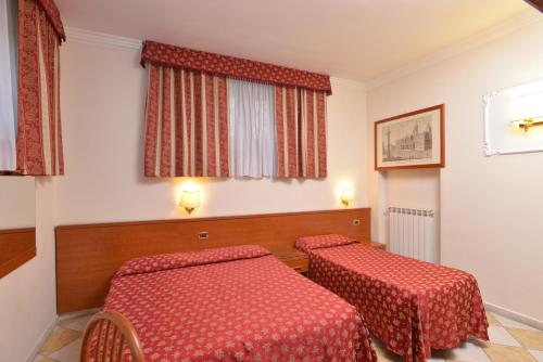 a room with two red tables and a window at Hotel Chicago in Rome