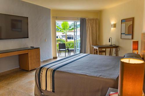 a hotel room with a large bed and a balcony at Friendly Fun Vallarta Different Experiences in Puerto Vallarta