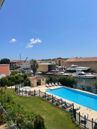 - une vue sur la piscine et le port de plaisance dans l'établissement Appartement avec piscine, à Grimaud