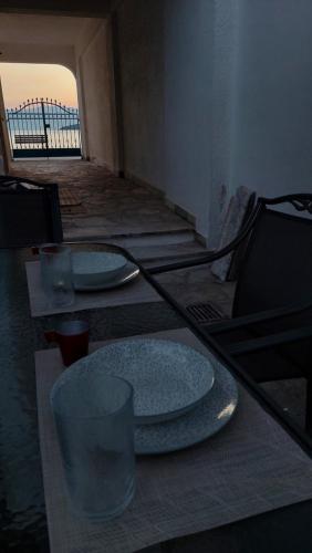 a table with two plates and glasses on top of it at Mitzela Mare House in Amaliápoli