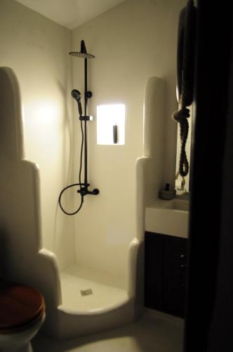 a bathroom with a toilet and a light on the wall at Mitzela Mare House in Amaliápoli