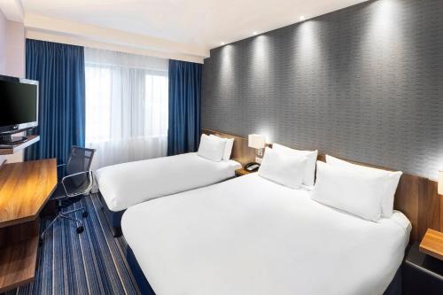 a hotel room with two beds and a television at Holiday Inn Express Amsterdam - South by IHG in Amsterdam