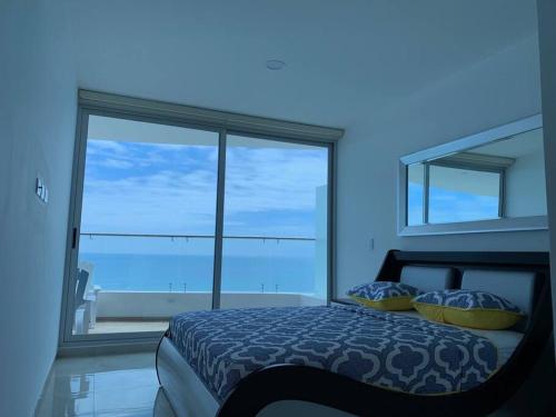 a bedroom with a bed with a view of the ocean at Grand Diamond Beach, Dep 2 dormitorios in Tonsupa