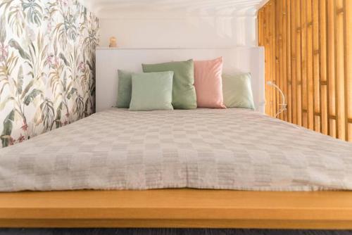 una cama con varias almohadas encima en Big Time - Apartment in the heart of Budapest, en Budapest