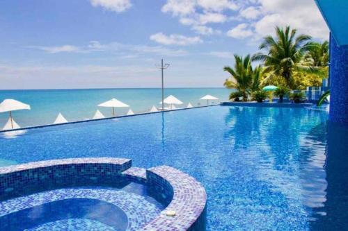 a swimming pool with the ocean in the background at Grand Diamond Beach, Dep 2 dormitorios in Tonsupa