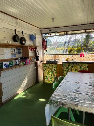 a dining room with a table and a window at ALAROOTS HUAHINE in Haapu