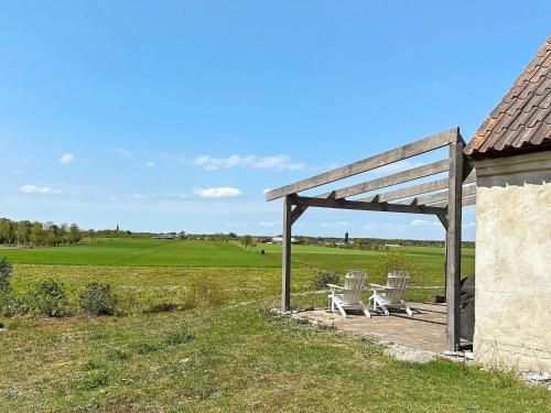 a picnic shelter with two chairs and a field at 6 person holiday home in Ljugarn-By Traum in Ljugarn