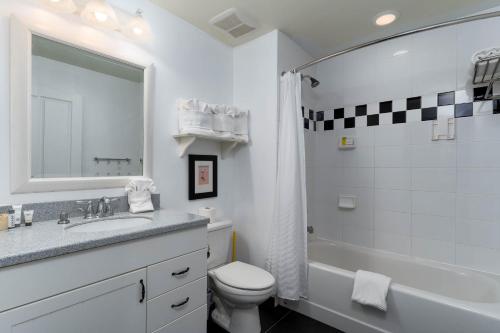 a white bathroom with a sink and a toilet at Harbour House at the Inn 207 in Fort Myers Beach
