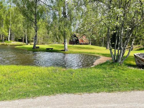 a body of water in a park with trees and grass at 7 person holiday home in KLÄSSBOL in Klässbol