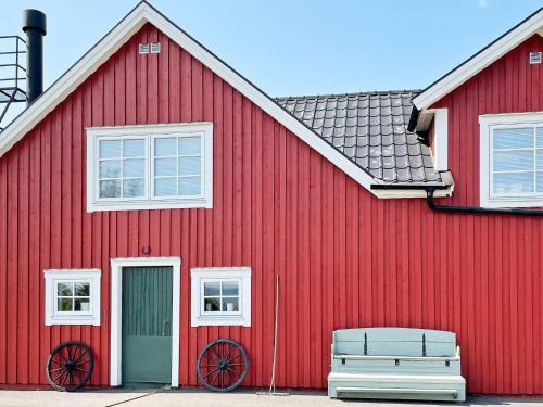 a red building with a bench in front of it at 8 person holiday home in BRÅLANDA-By Traum in Brålanda