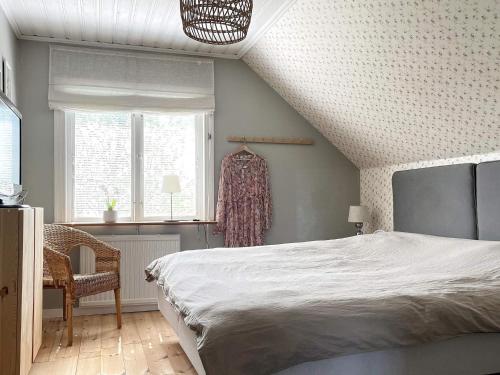 ÖdeshögにあるHoliday home öDESHöG IIIのベッドルーム1室(ベッド1台、椅子、窓付)