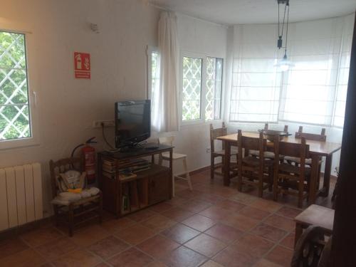 a living room with a television and a table and chairs at El huerto de la Reina in Becerril de la Sierra