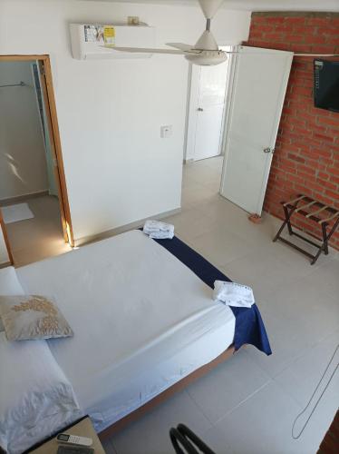 a bed in a room with a brick wall at Alojamiento Turístico Verano Azul San Andrés in San Andrés
