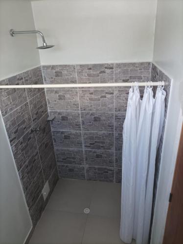 a shower with a white shower curtain in a bathroom at Alojamiento Turístico Verano Azul San Andrés in San Andrés