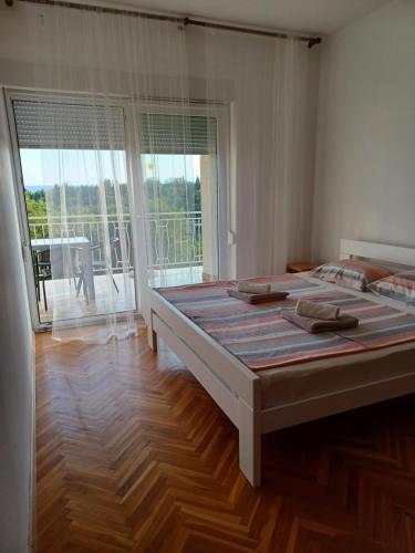 a large bed in a room with a large window at Apartment Lucija in Dramalj