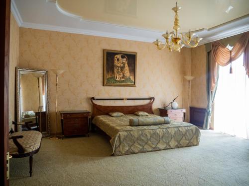 a bedroom with a bed and a mirror and a chandelier at Hotel Madrid in Odesa
