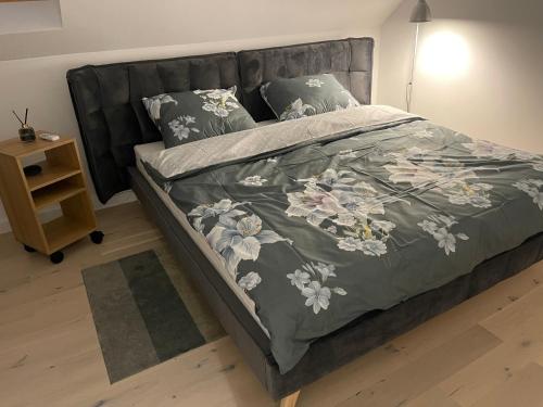sypialnia z łóżkiem z szarym kocem i poduszkami w obiekcie Appena Guest House w Krakowie