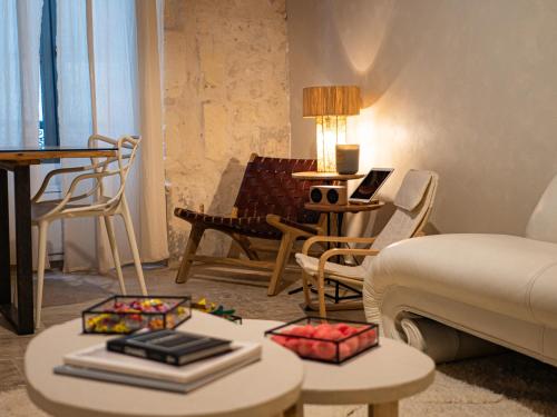 - un salon avec un lit et une table avec des livres dans l'établissement Pamp’Arles, à Arles