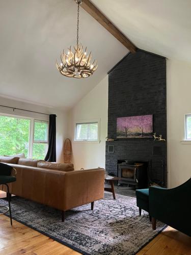 a living room with a couch and a fireplace at The Brookside Lodge & Cottage in Dover