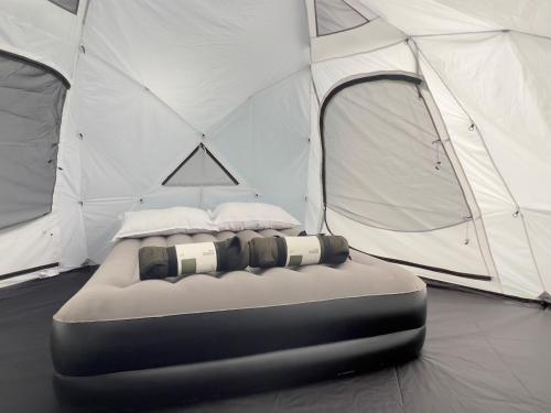 a bed in front of a white tent at Iceland Igloo Village in Hella