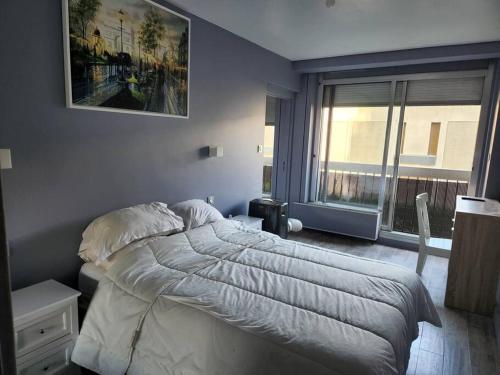 um quarto com uma cama grande e uma janela em Appartement cosy Puteaux centre em Puteaux
