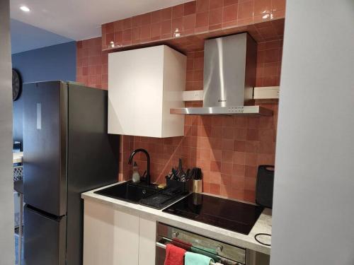 uma cozinha com um lavatório e um frigorífico em Appartement cosy Puteaux centre em Puteaux