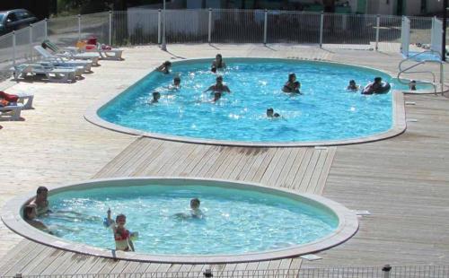 un groupe de personnes dans une piscine dans l'établissement Mobil-home + jardin au Camping du lac, à Égletons