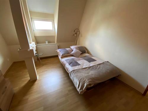 a bedroom with a bed in a room with a window at Pokoje W Pięknej Kamienicy W Centrum W Głogówku in Głogówek