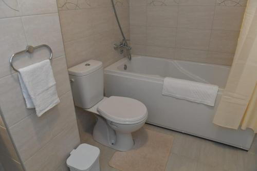 uma casa de banho com um WC branco e uma banheira em Dobi Apartmani WING 7 em Jagodina