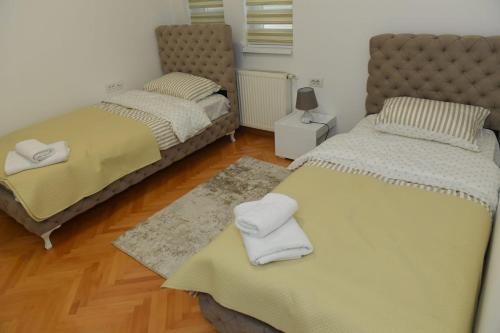 um quarto com 2 camas e toalhas em Dobi Apartmani WING 7 em Jagodina