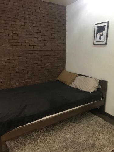 a bed in a room with a brick wall at Квартира подобово, погодинно (Центр) Стрий in Stryi