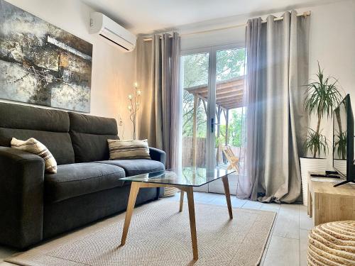 a living room with a couch and a glass table at Les Lodges de Saint Cassien 2 in Montauroux