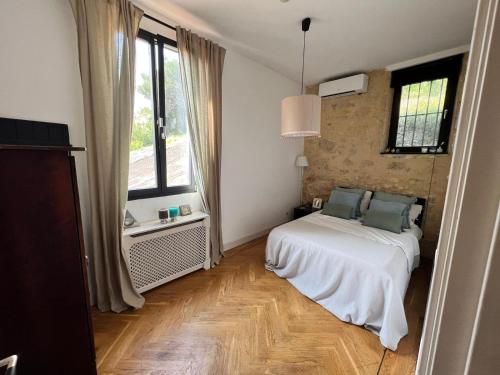 a white bedroom with a bed and a window at Villa pont du Gard 4 Bedrooms in Remoulins