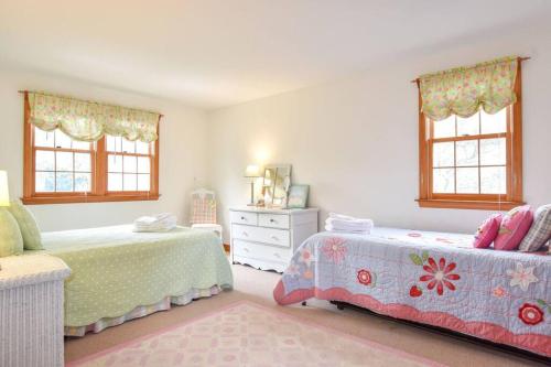 um quarto com 2 camas, uma cómoda e janelas em Great Location Outdoor Space Dog Friendly em Chatham