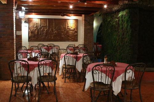 un groupe de tables et de chaises dans une pièce dans l'établissement Hotel Boyeros, à Liberia