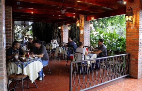 a group of people sitting at tables in a restaurant at Hotel Boyeros in Liberia