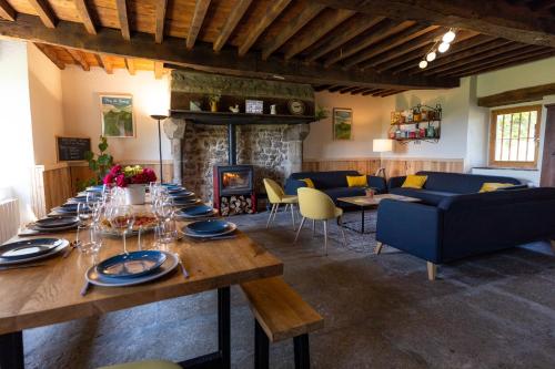 un salon avec une table et une cheminée dans l'établissement Domaine du COQ en PAT, à Augerolles