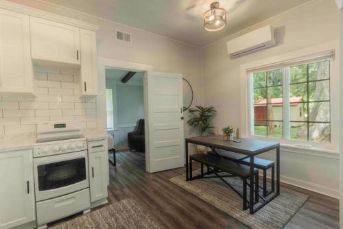 a kitchen with a table and a stove and a window at Cozy Cottage at the Springs in De Leon Springs