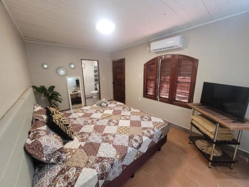 um quarto com uma cama e uma secretária com um teclado em Naturalis Flats and Suites em Puerto Iguazú