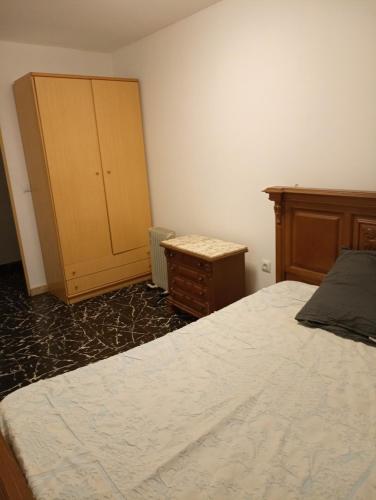 a bedroom with a bed and a dresser and a cabinet at Chambre economique in Gandía