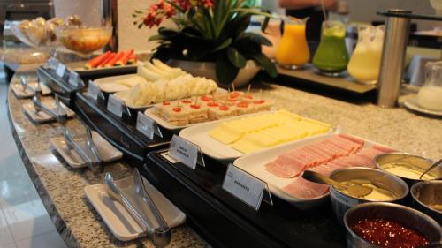 a buffet with different types of food on a counter at Hotel Aliança Express in Rio do Sul