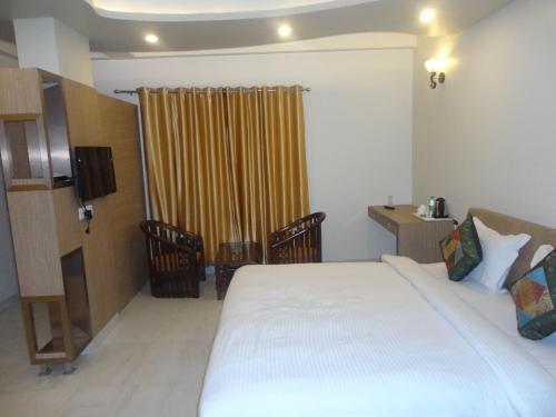 a hotel room with a bed and a yellow curtain at Hotel Banaras Haveli in Varanasi