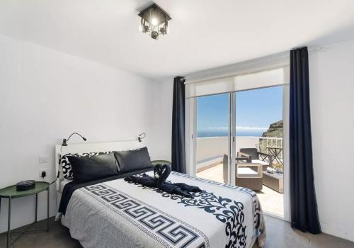 um quarto com uma cama e vista para o oceano em Yinfa 1 Sunset Apartment em Tamaimo