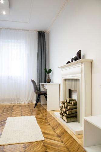 a living room with a fireplace and a table at Season One Apartman in Szeged