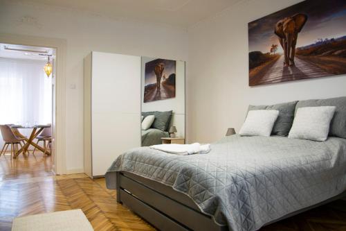 a bedroom with a bed and a painting on the wall at Season One Apartman in Szeged